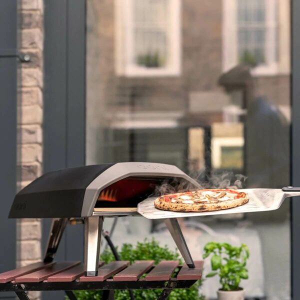 Cooked pizza being removed from an Ooni Koda 12